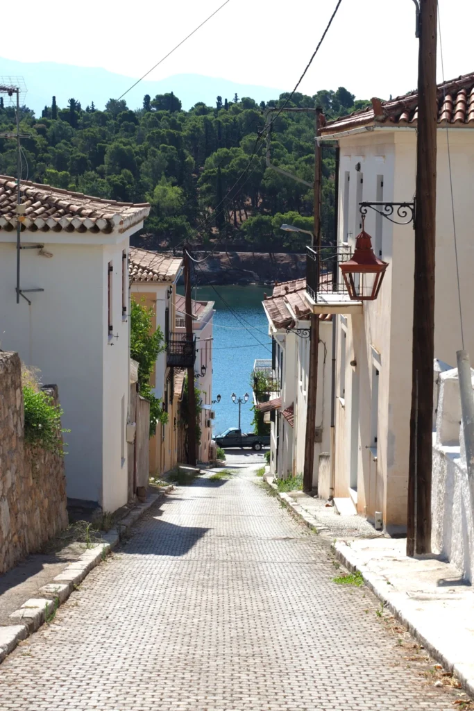Narrow paved lane descending between traditional houses in Galaxidi