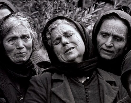 Women performing moirologia beside a grave in Mani, Greece, in 1962.