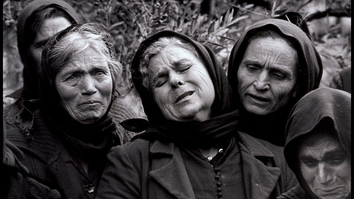 Women performing moirologia beside a grave in Mani, Greece, in 1962.