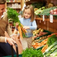 father and daughter buying veggies