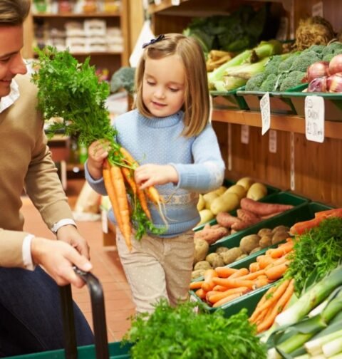 father and daughter buying veggies