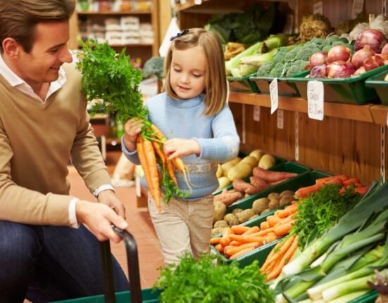 father and daughter buying veggies