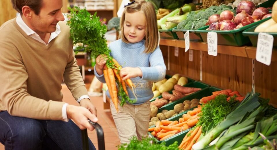 father and daughter buying veggies