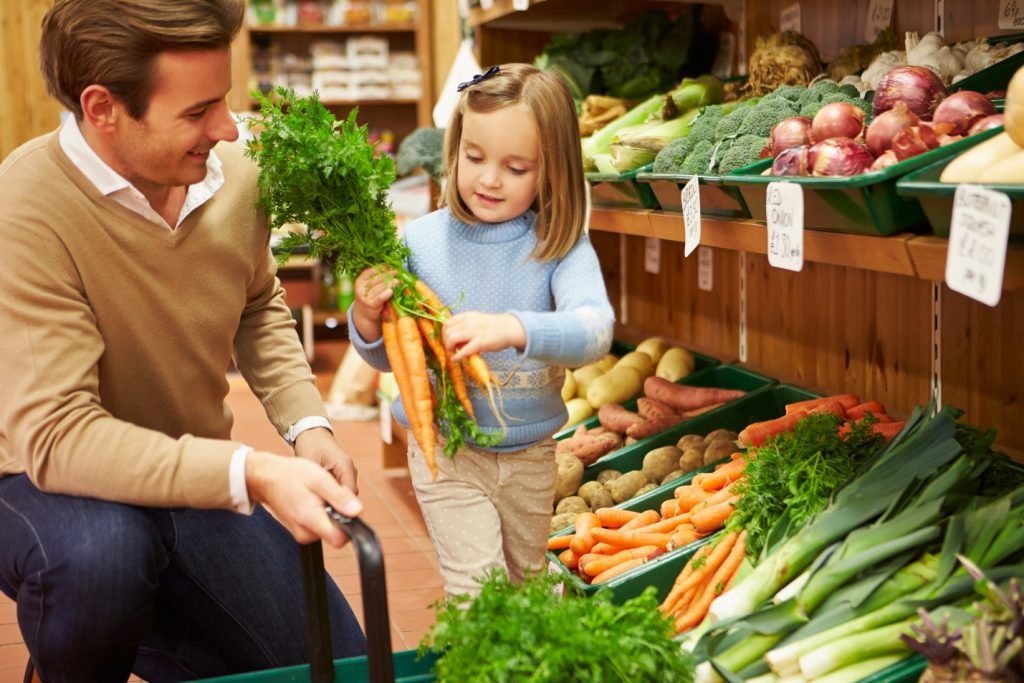 father and daughter buying veggies