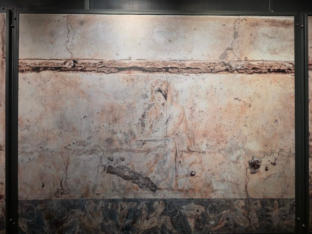 Close-up of the eastern wall fresco from Tomb I (Tomb of Persephone) showing a seated woman, likely Demeter, wrapped in her himation on the Agelastos Petra, mourning Persephone’s abduction. Museum of the Royal Tombs of Aigai, Expats Athens, Expats Greece, Xpat.gr
