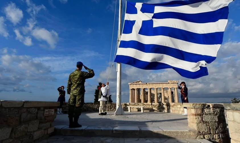 Greek Independence Day, Greek flag waves above the Acropolis as soldiers salute