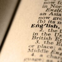 Close-up photograph of the word “English” on a vintage dictionary page, symbolising the history and evolution of the English language.