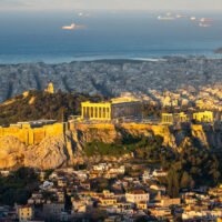 The Acropolis and Parthenon overlooking modern Athens and the Saronic Gulf, Greece.