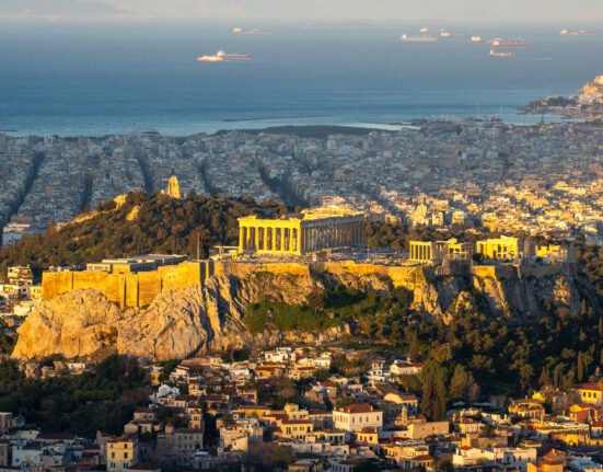 The Acropolis and Parthenon overlooking modern Athens and the Saronic Gulf, Greece.