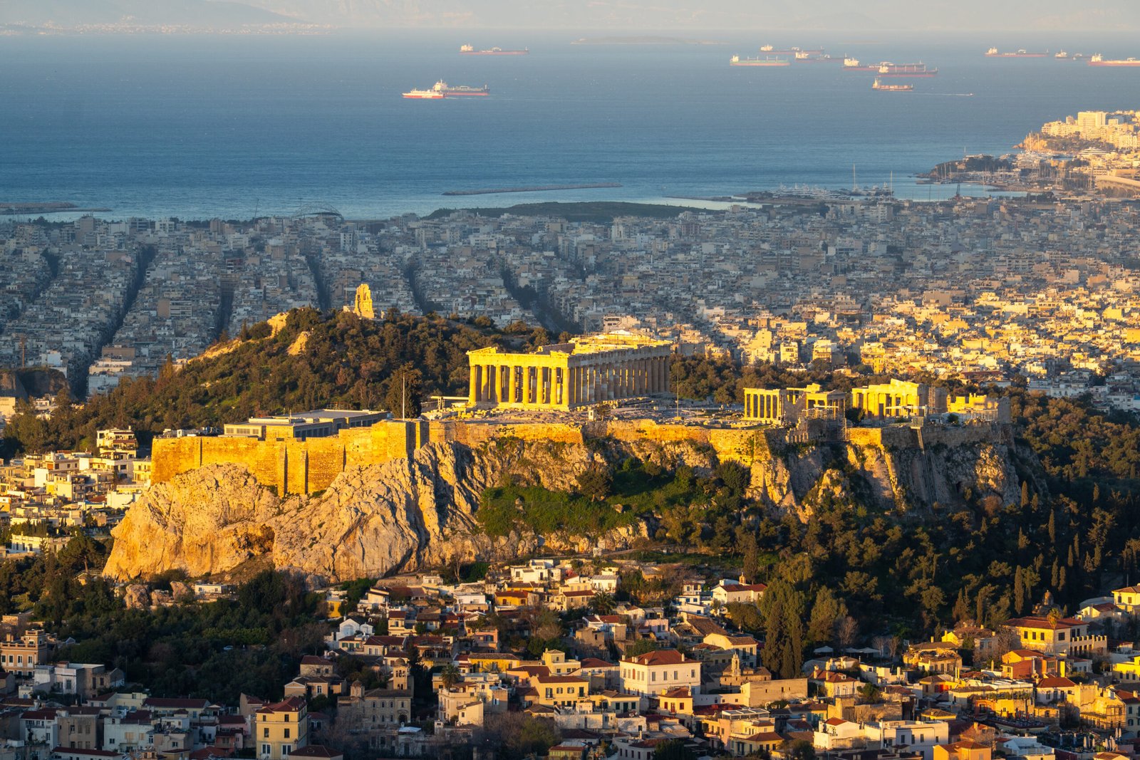 The Acropolis and Parthenon overlooking modern Athens and the Saronic Gulf, Greece.