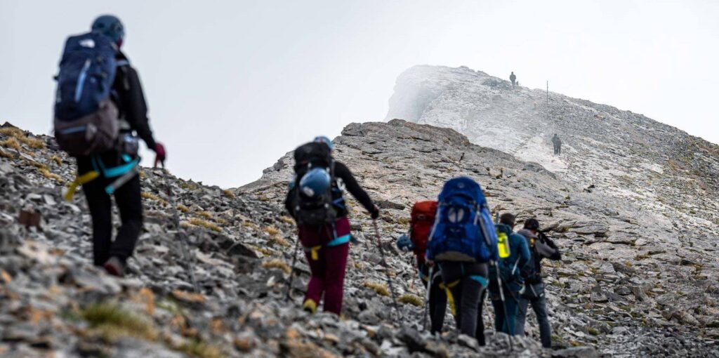 Hikers ascending rocky alpine terrain on Mount Olympus during an Unlimited Adrenaline activity featured on Xpat.gr