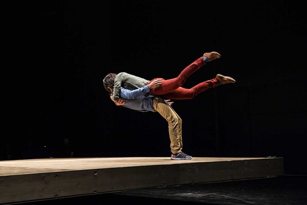 Two dancers performing He Who Falls by Yoann Bourgeois Art Company on stage.