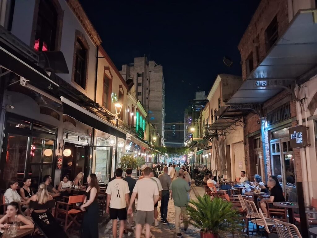 Crowds walking between cafés and restaurants in Ladadika, Thessaloniki, on a lively summer evening.