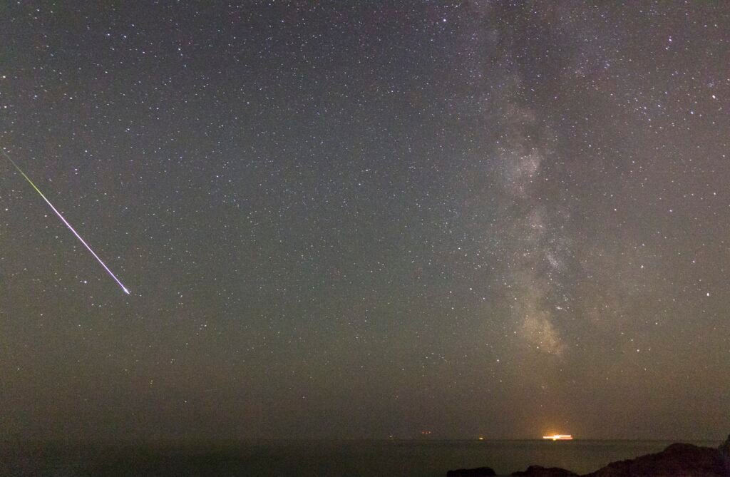 Bright Perseid fireball crossing the night sky over Sounion, Attica, Greece.