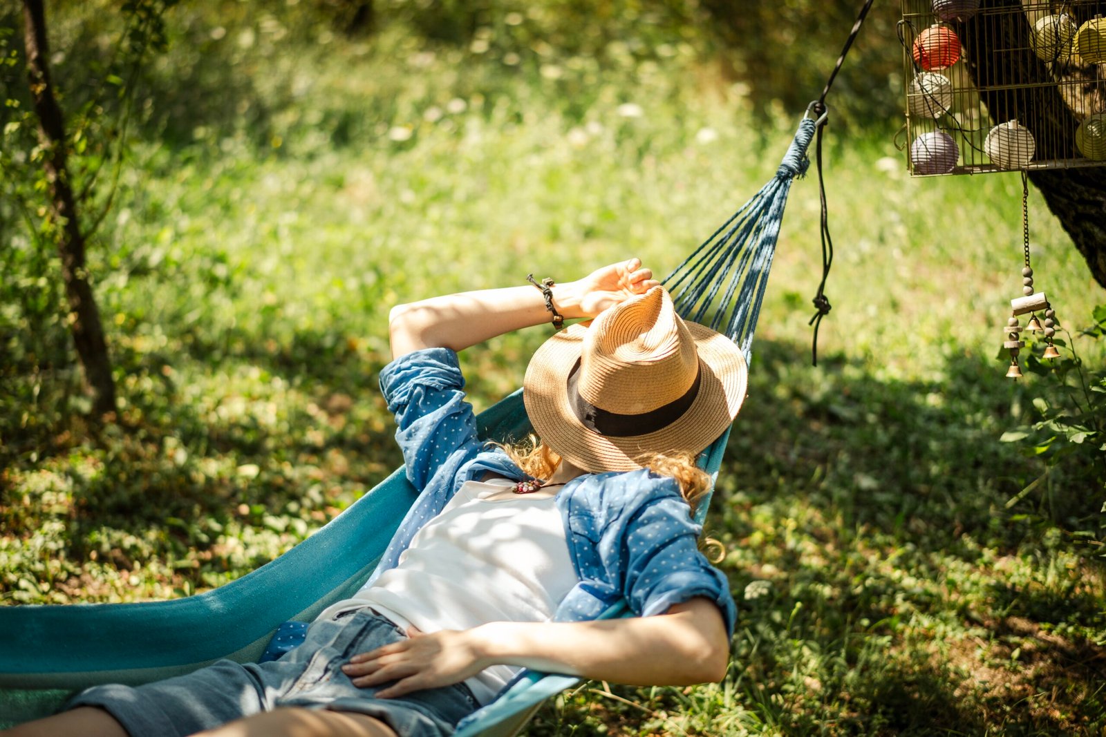 Woman resting in a hammock outdoors, enjoying a peaceful afternoon nap in the shade.