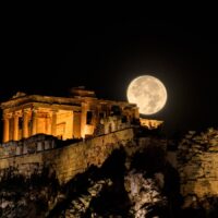 August full moon rising over the illuminated Acropolis in Athens, Greece