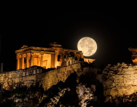 August full moon rising over the illuminated Acropolis in Athens, Greece