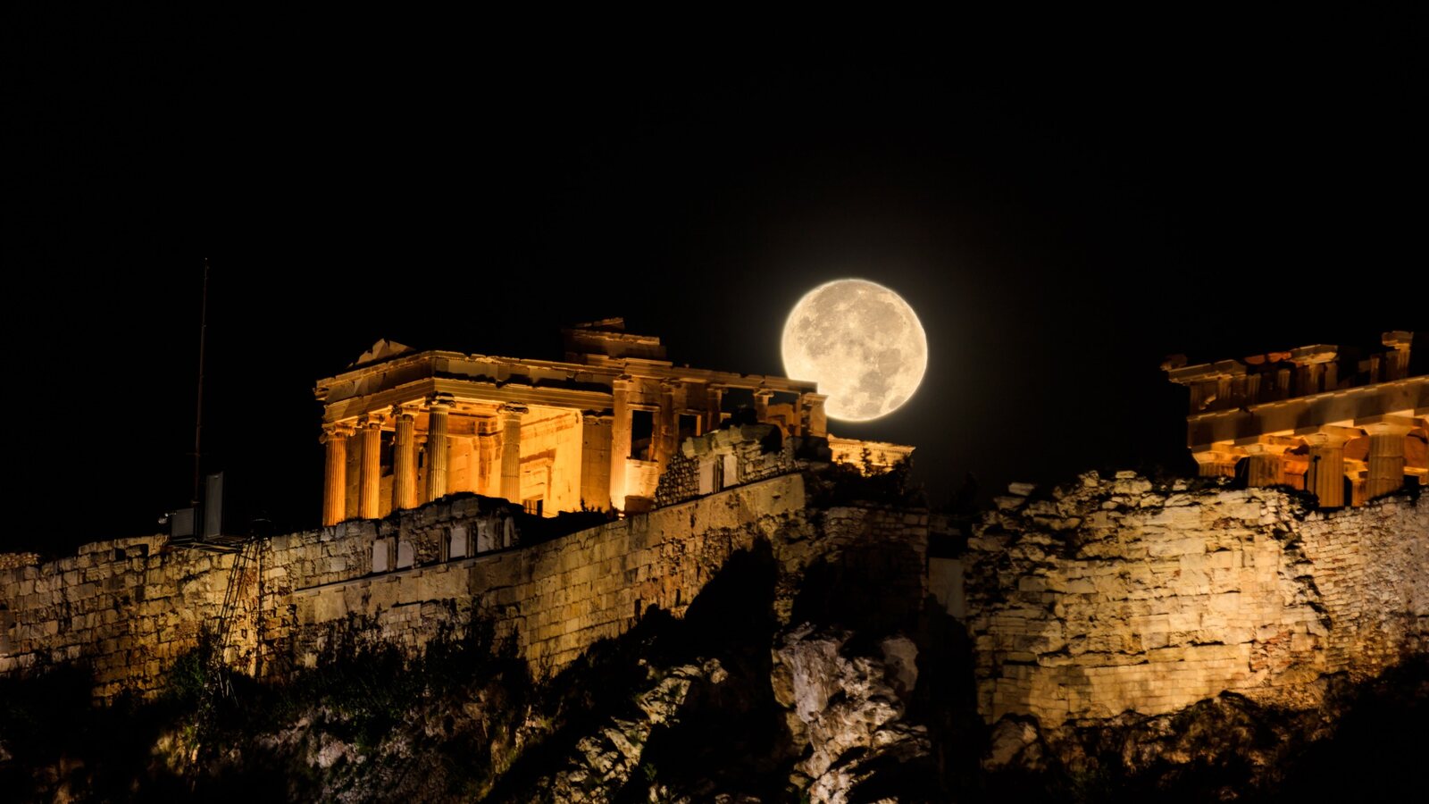 August full moon rising over the illuminated Acropolis in Athens, Greece