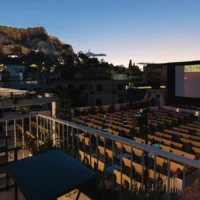 Cine Paris open-air cinema overlooking the illuminated Acropolis at dusk