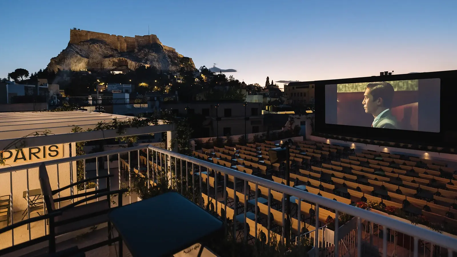 Cine Paris open-air cinema overlooking the illuminated Acropolis at dusk