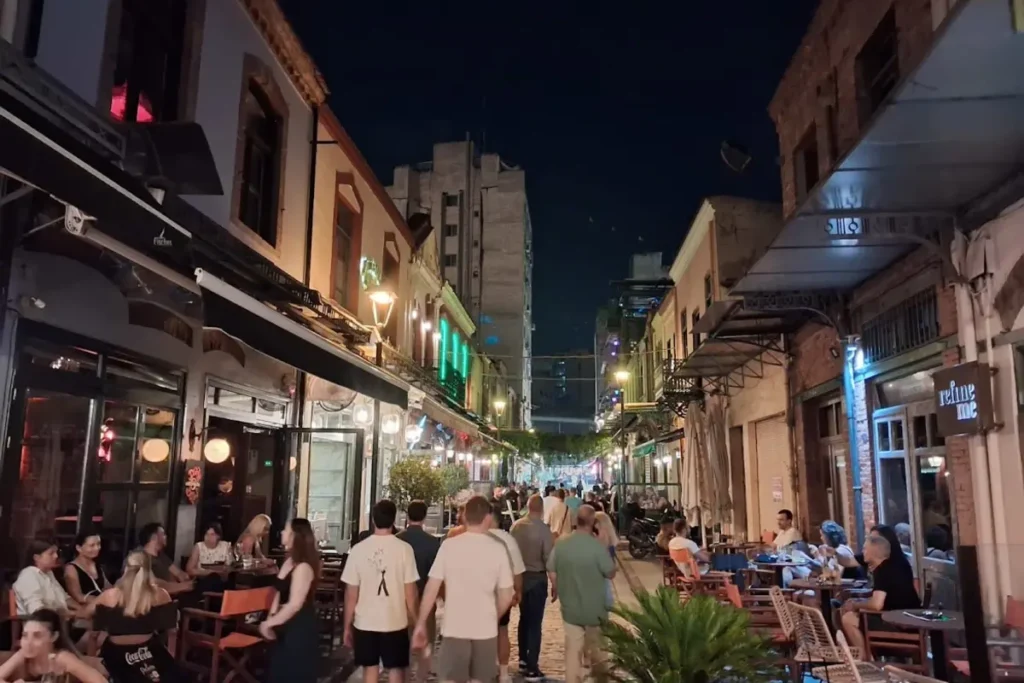 Crowds walking between cafés and restaurants in Ladadika, Thessaloniki, on a lively summer evening.
