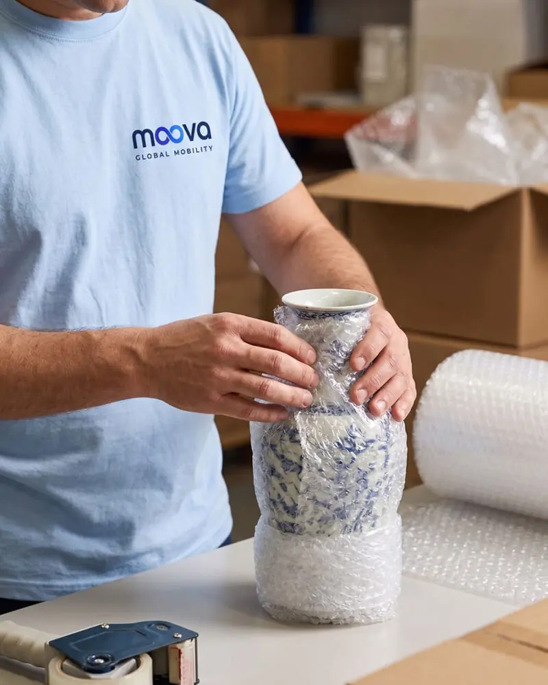 MOOVA professional carefully packing a ceramic vase for transport