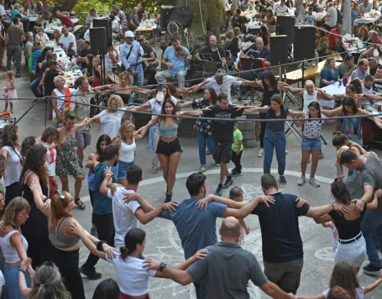 People dancing in a circle at a traditional village panigiri in Ikaria, Greece