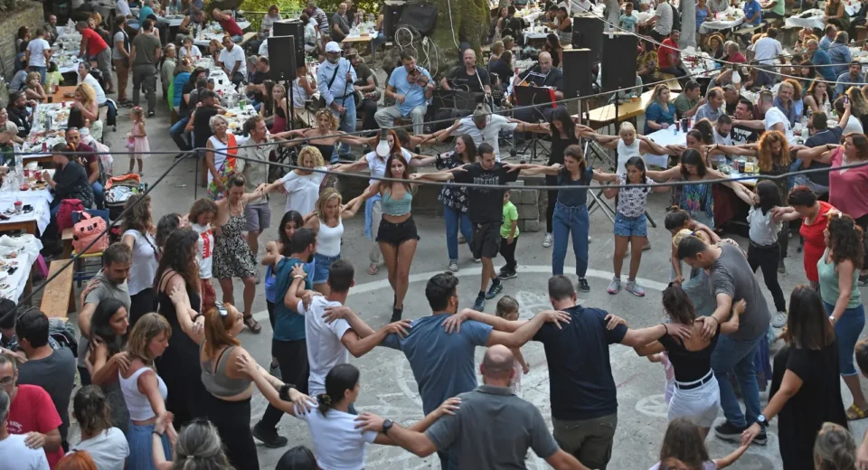 People dancing in a circle at a traditional village panigiri in Ikaria, Greece