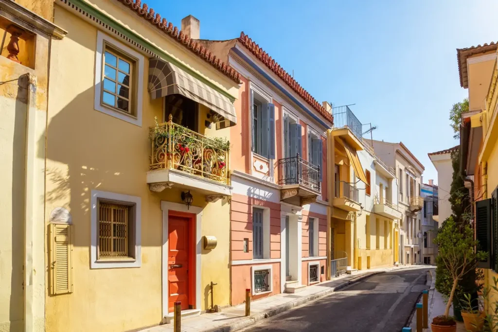 Quiet residential street in Plaka, Athens, with colourful houses, balconies and shutters on a bright summer afternoon.