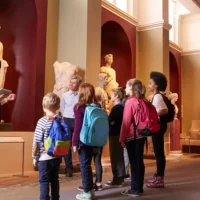Pupils visiting a museum with their teacher and a guide during a school trip
