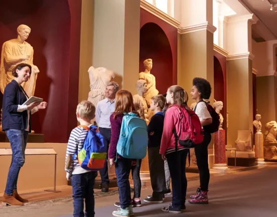 Pupils visiting a museum with their teacher and a guide during a school trip