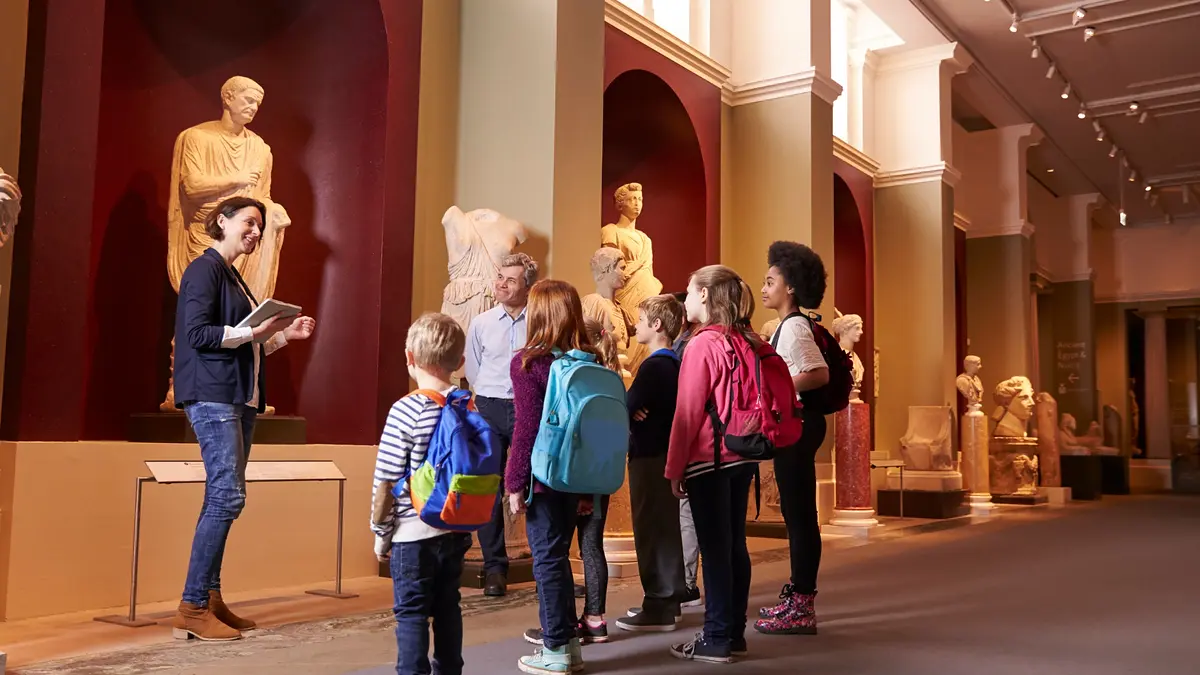 Pupils visiting a museum with their teacher and a guide during a school trip