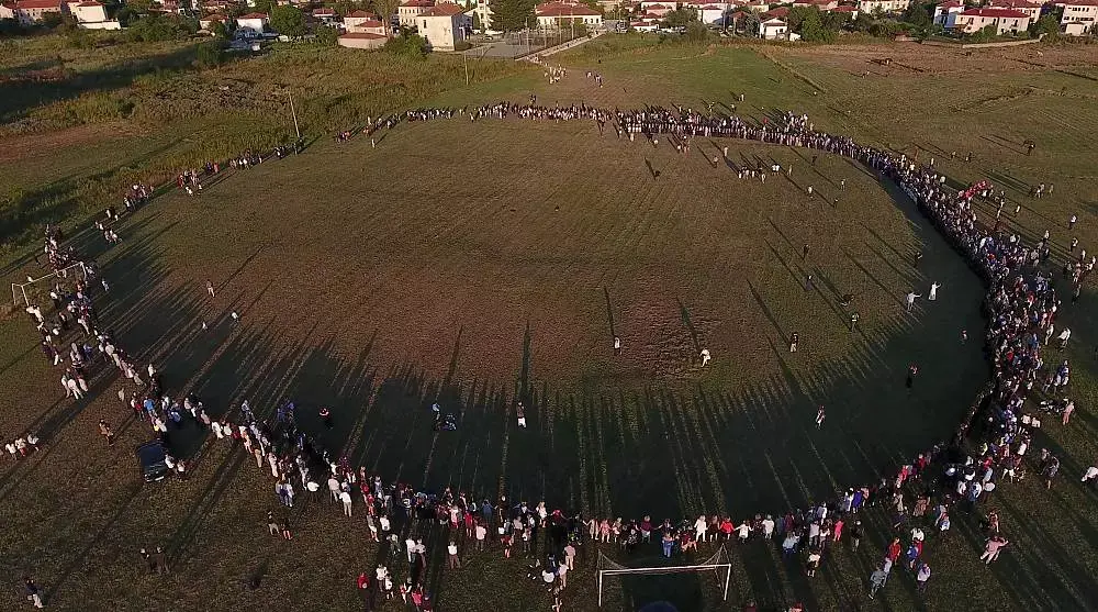 An aerial view of participants forming a large open circle for the Tranos Choros in Vlasti.