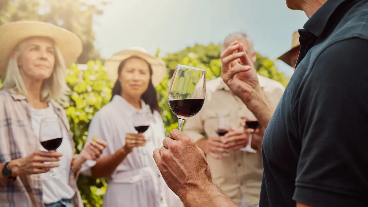 Visitors tasting red wine at a vineyard during a Greek wine festival