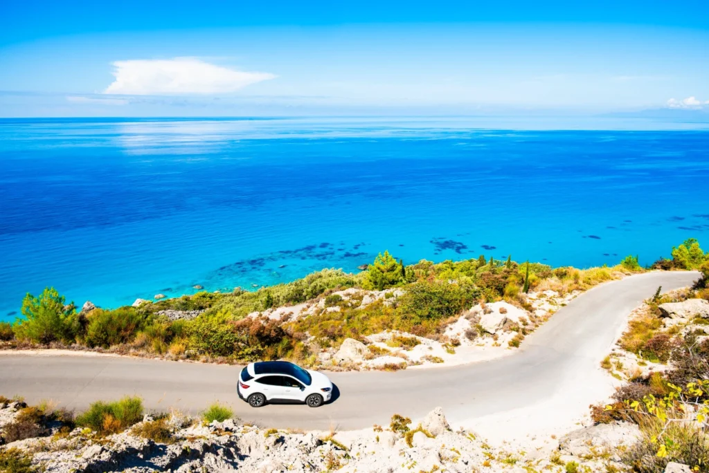 Car driving along a coastal road in Greece