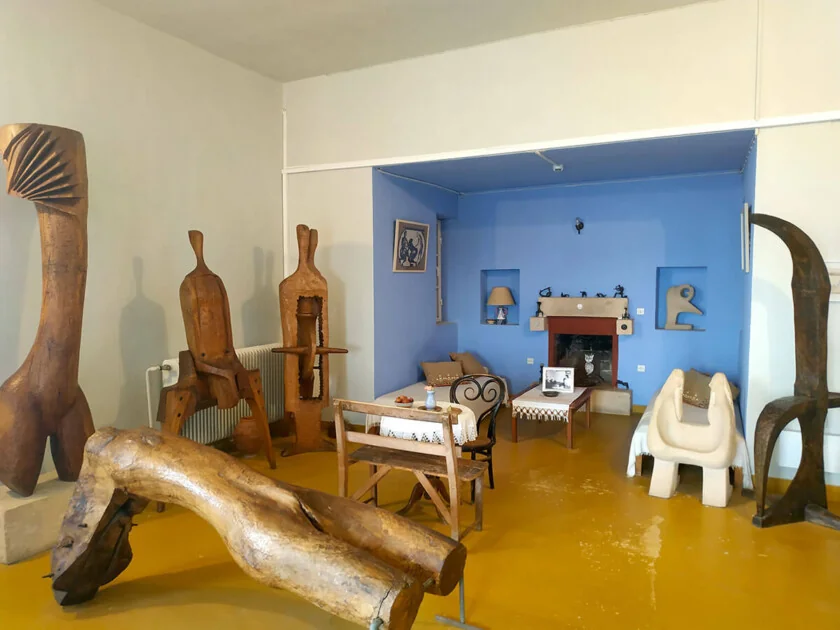 Sculptures displayed around furniture and a fireplace inside the Christos Kapralos Museum.