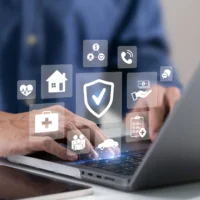Insurance protection icons for health, home, car and financial cover displayed over a laptop screen