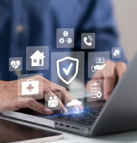 Insurance protection icons for health, home, car and financial cover displayed over a laptop screen