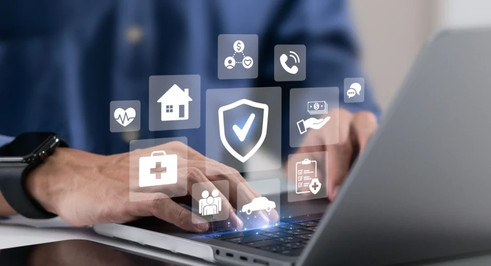 Insurance protection icons for health, home, car and financial cover displayed over a laptop screen