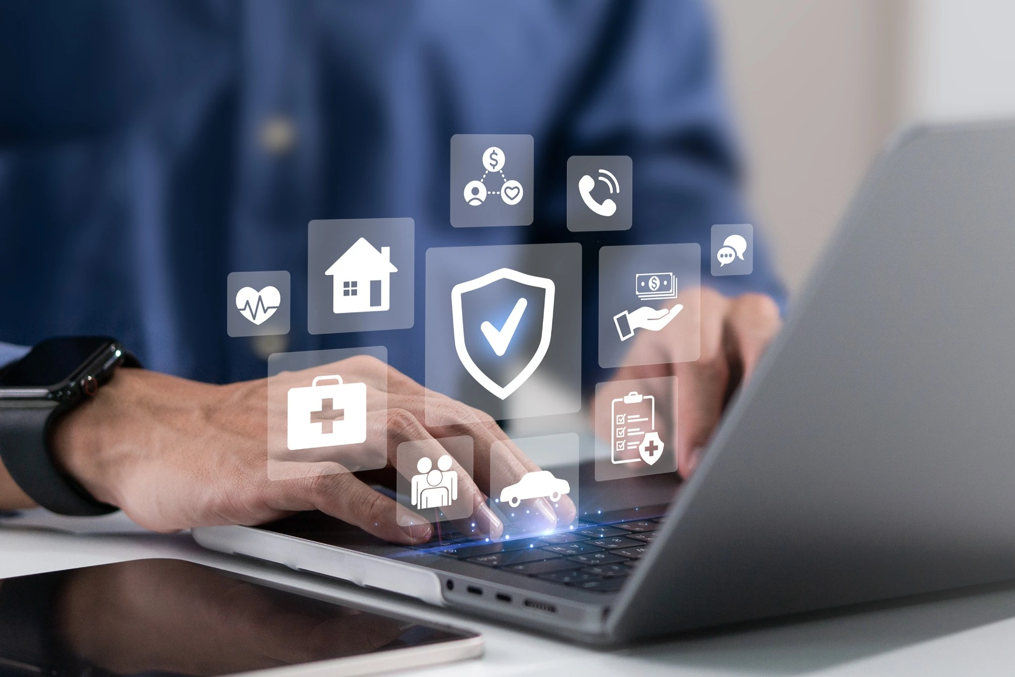 Insurance protection icons for health, home, car and financial cover displayed over a laptop screen