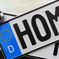 Foreign vehicle registration plates with a car key and documents, illustrating foreign-registered car rules in Greece.