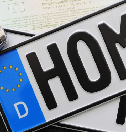 Foreign vehicle registration plates with a car key and documents, illustrating foreign-registered car rules in Greece.