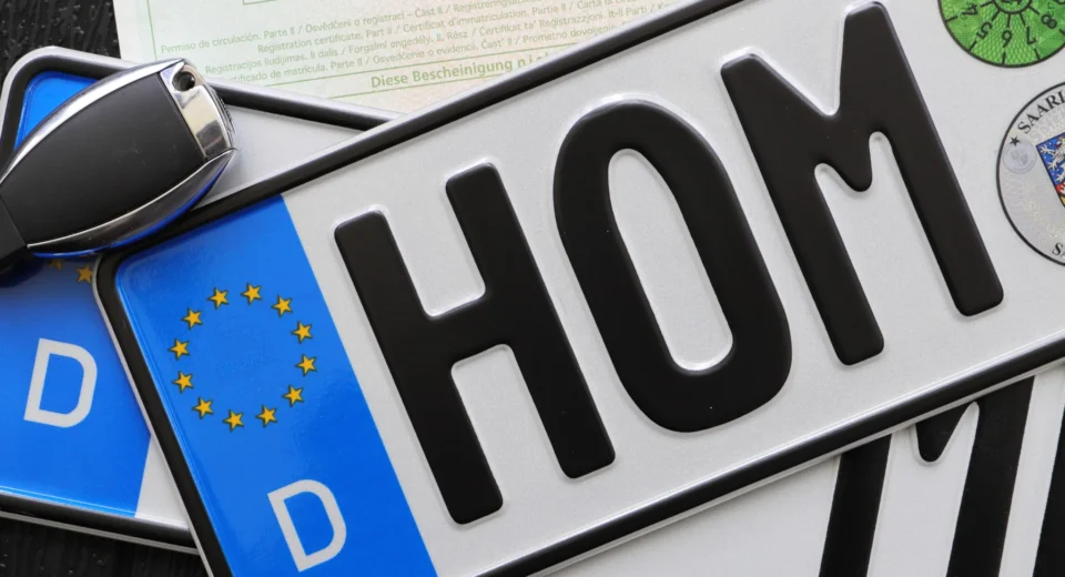 Foreign vehicle registration plates with a car key and documents, illustrating foreign-registered car rules in Greece.