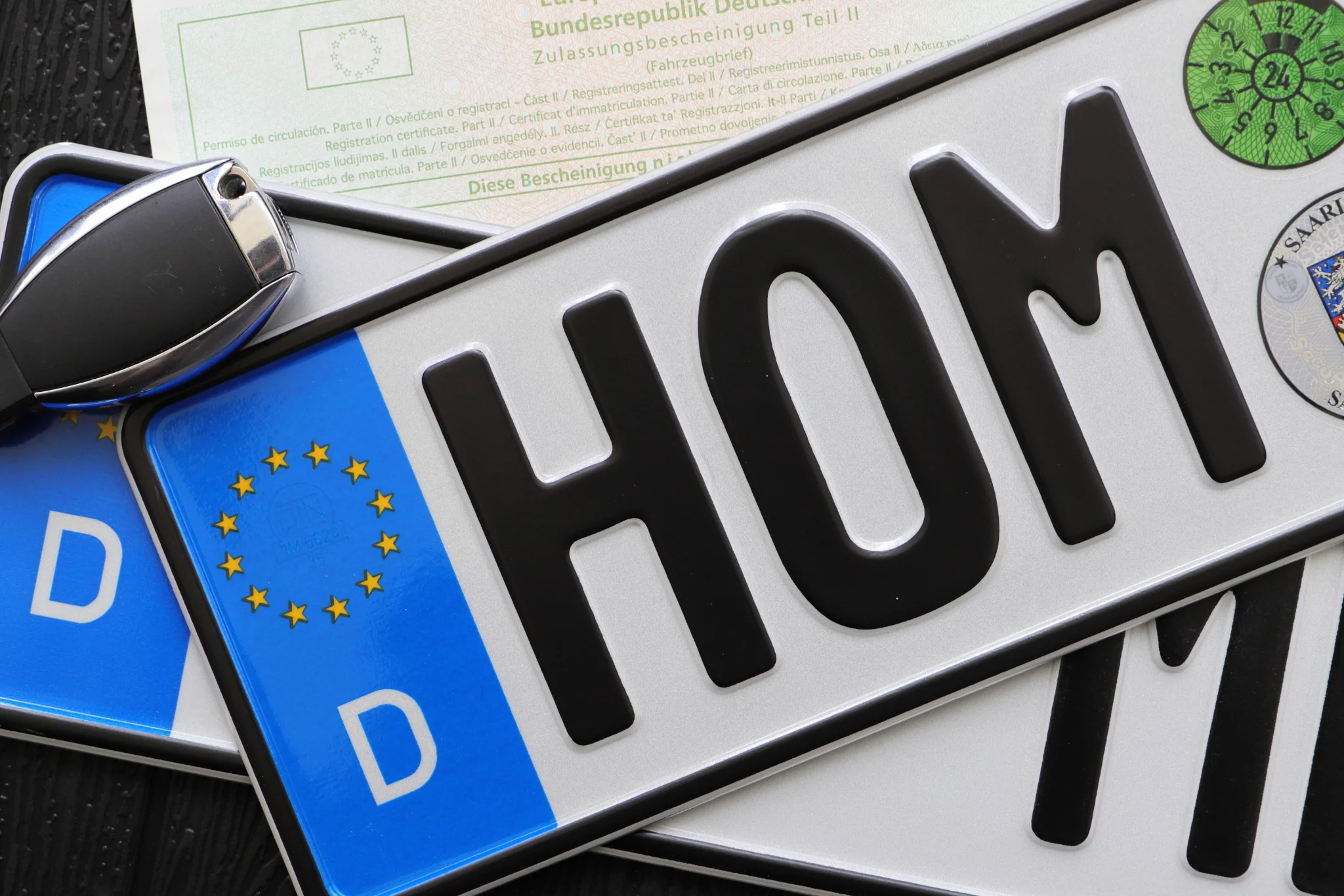 Foreign vehicle registration plates with a car key and documents, illustrating foreign-registered car rules in Greece.