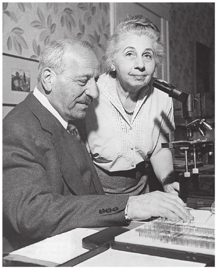 Georgios and Machi Papanikolaou working beside a microscope.