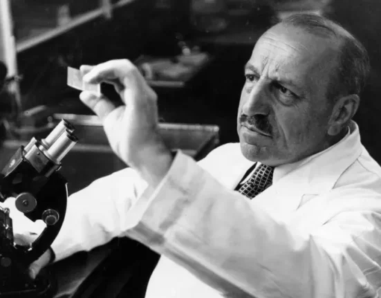 Georgios Papanikolaou examining a microscope slide in his laboratory.
