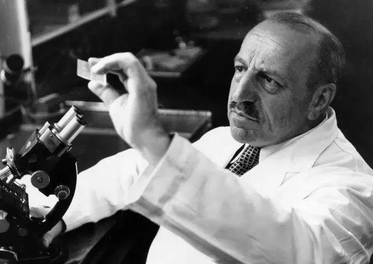 Georgios Papanikolaou examining a microscope slide in his laboratory.