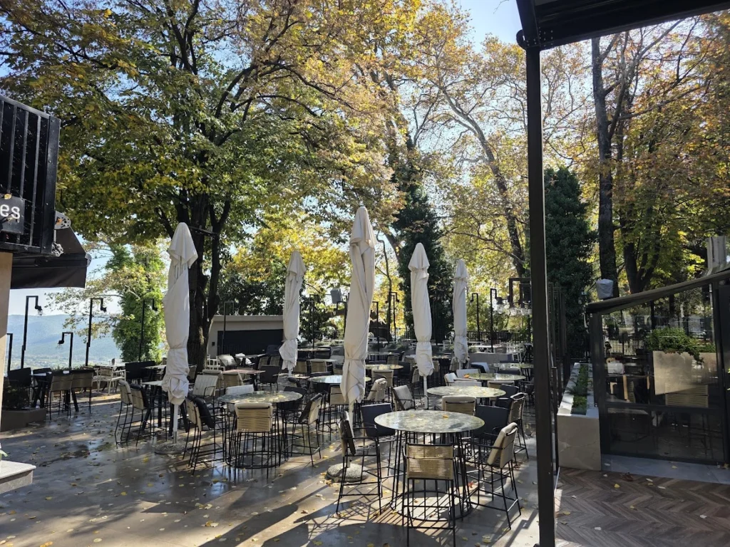 Tree-shaded terrace of Katarraktes Estiatorio-Kafe beside Edessa Waterfall Park