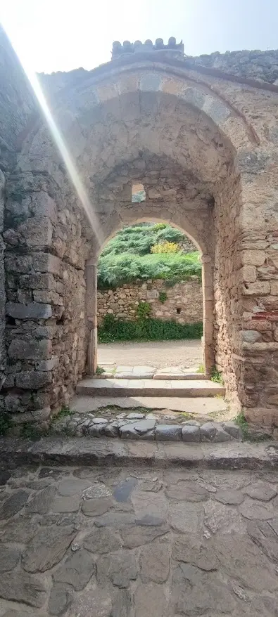 Sunlight passing through a vaulted medieval stone passage in Mystras