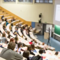 Students attending a university lecture in a large auditorium